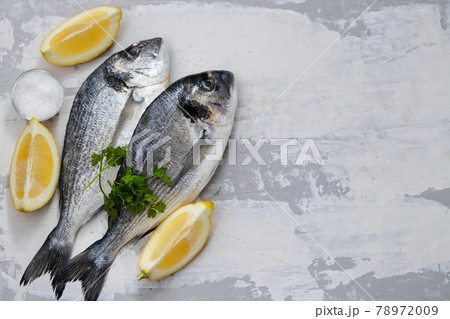 raw fish with olive oil and lemon background 78972009