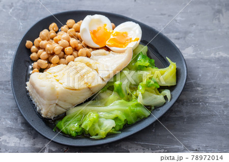 fried cod fish with chick pea, boiled egg and cabbage on dark dish fried cod fish with chick pea, boiled egg and cabbage on dark dish 78972014