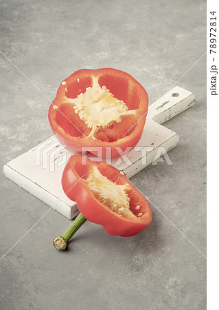 halved red bell pepper on a wooden cutting board on gray background halved red bell pepper on a wooden cutting board on gray background 78972814