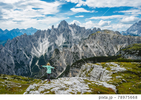 Aerial view of a woman hiker in green jacket with raised hands admiring Cadini di Misurina mountain peaks of Italian Alps, Dolomites, Italy, Europe Aerial view of a woman hiker in green jacket with raised hands admiring Cadini di Misurina mountain peaks of Italian Alps, Dolomites, Italy, Europe 78975668