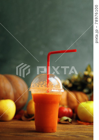 Pumpkins juice in bottles with pumpkins. 78976100