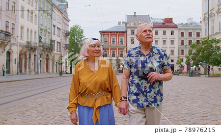 Senior old stylish tourists man, woman, grandmother, grandfather family having a walk in summer city 78976215