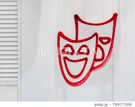 Theatrical masks of tragedy and comedy. Red graffiti on white wall. Urban nameless art. Symbols and signs on building surfaces. 78977306