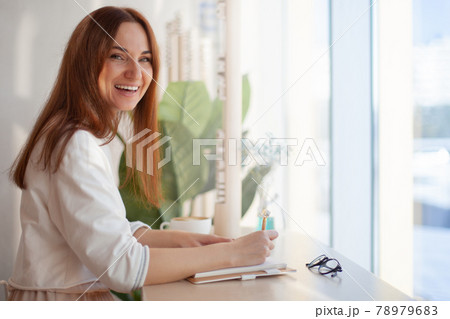 Young businesswoman in eyeglasses planning and writing down the daily schedule with in agenda 78979683