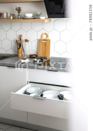 Comfortable white gray kitchen interior open box full of various crockery porcelain or glass plates Comfortable white gray kitchen interior open box full of various crockery porcelain or glass plates 78982356