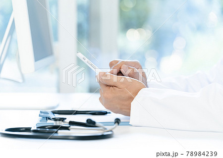スマホを操作する医師の手元 78984239