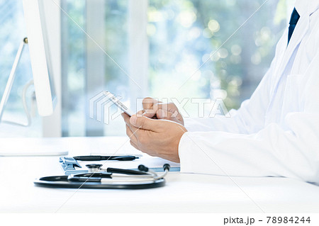 スマホを操作する医師の手元 78984244
