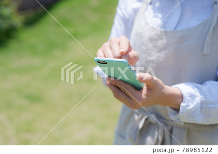 スマホを持つ主婦の手元 78985122