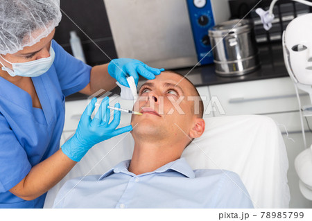 Man receiving cosmetic facial injection in clinic Man receiving cosmetic facial injection in clinic 78985799