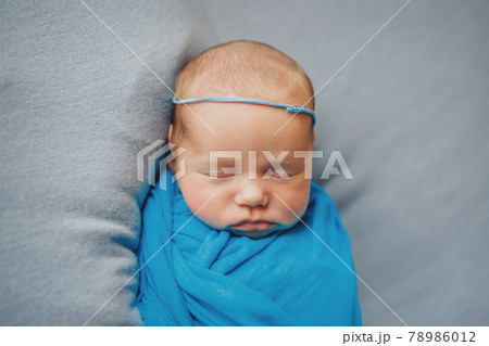 the face of a child with a bandage with flowers on his head close-up 78986012