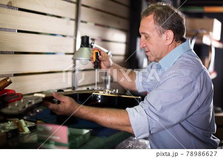 Music master is repairing music instruments 78986627