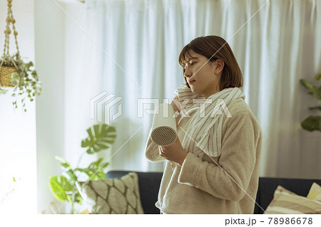 リビングで髪の毛を乾かす若い女性 リビングで髪の毛を乾かす若い女性 78986678