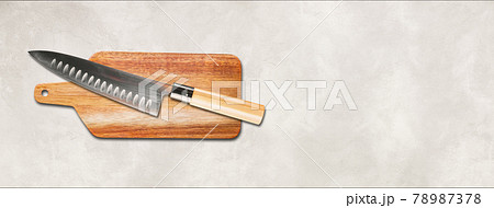 Traditional Japanese gyuto chief knife on a cutting board. White concrete background banner 78987378