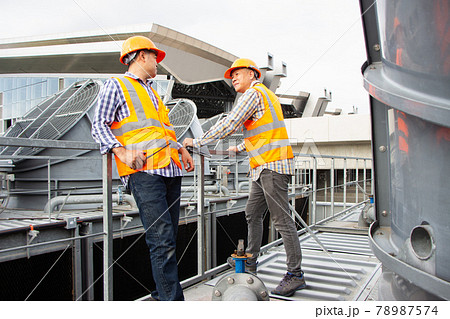 Asian male engineer inspecting pipe fittings and chillers, refrigeration plant refrigeration plant in factory. male mechanic wearing helmet and Reflective Safety Vest uses laptop, tablet, equipment Asian male engineer inspecting pipe fittings and chillers, refrigeration plant refrigeration plant in factory. male mechanic wearing helmet and Reflective Safety Vest uses laptop, tablet, equipment 78987574