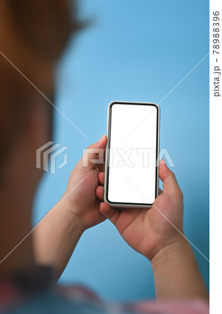 Rear view young man holding mock up smart phone over blue background. 78988396