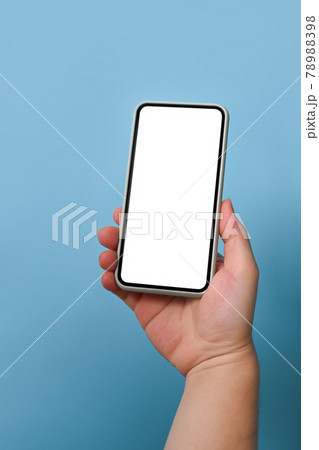 Cropped shot man holding mock up mobile phone over blue background. 78988398