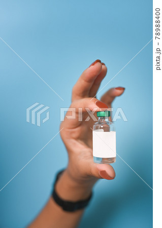 Woman showing vaccine bottle . 78988400