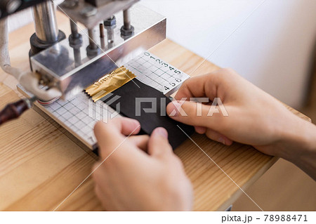 Male tanner stamping stuff use awl and machine device working at leather workshop. Handmade work Male tanner stamping stuff use awl and machine device working at leather workshop. Handmade work 78988471