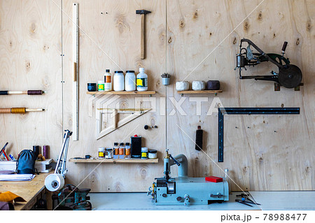 Wooden wall at leather workshop. Different tools and equipment for handcraft working tanner Wooden wall at leather workshop. Different tools and equipment for handcraft working tanner 78988477