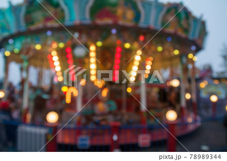 A blurry colorful carousel in the amusement park at evening illumination. The effect of bokeh 78989344