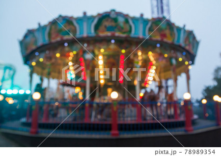 A blurry colorful carousel in the amusement park at evening illumination. The effect of bokeh 78989354