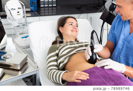 Woman getting ultrasound procedure for body contouring Woman getting ultrasound procedure for body contouring 78989746