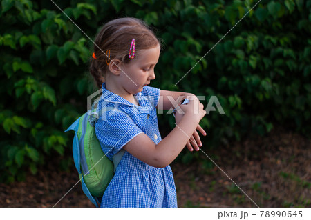 Kid using smartwatch outdoor. Child talking on the smartphone. Schoolgirl using touchscreen on watches browsing internet 78990645