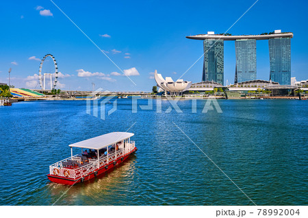 Tourist cruise boat navigating in Marina Bay, Singapore. iconic Marina Bay Sands, Shoppes mall, ArtScience museum, Helix bridge and Singapore Flyer. Tourist cruise boat navigating in Marina Bay, Singapore. iconic Marina Bay Sands, Shoppes mall, ArtScience museum, Helix bridge and Singapore Flyer. 78992004