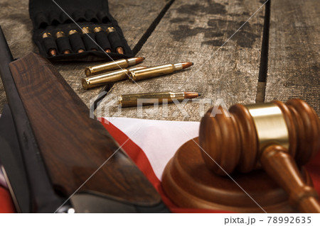 Wooden judge gavel and hunting rifle over USA flag on wooden background 78992635