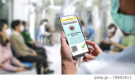 Traveler holds vaccine passport certificate to show COVID 19 vaccination status 78992811