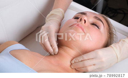 Chin massage of woman young woman during face massage at beauty salon Chin massage of woman young woman during face massage at beauty salon 78992817