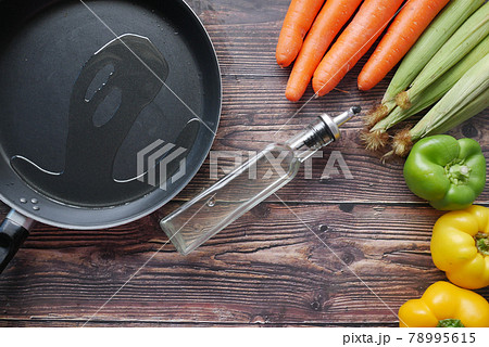 Pouring vegetable oil into frying pan. Pouring vegetable oil into frying pan. 78995615