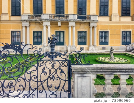 perfect lawn, forged gates near the building, garden sculpture, flowerbed with white tulips, closed windows 78996966