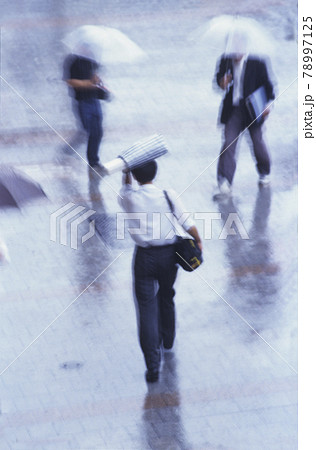 仕事中に外は突然の雨。歩く人々は傘あり傘なしチョットそこまで小走りで雨宿り 78997125