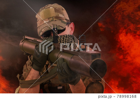 Private Military Contractor firing RPG (rocket propelled grenade) - soviet bazooka type grenade launcher. Flame and smoke on background. Private Military Contractor firing RPG (rocket propelled grenade) - soviet bazooka type grenade launcher. Flame and smoke on background. 78998168