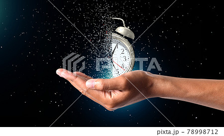 Clock  Dispersing in hand Concept of passing away, the clock breaks down into pieces. Hand holding analog clock with dispersion effect 78998712