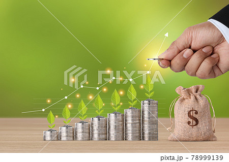 Business investment and saving growth for advertising concept. Businessman hand stacking coin growing and plant growing with growth graph chart and money bag on wood table, meaning of tax or earning 78999139
