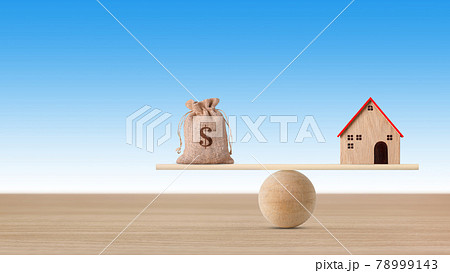 Model house on wooden seesaw balancing with money bag on blue background. Property investment and home mortgage financial real estate advertising concept 78999143