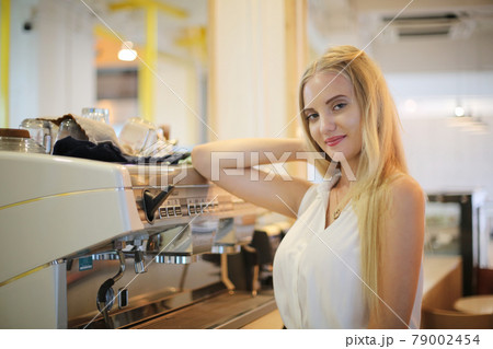 Close-up of Beautiful woman using coffee machine in kitchen Close-up of Beautiful woman using coffee machine in kitchen 79002454