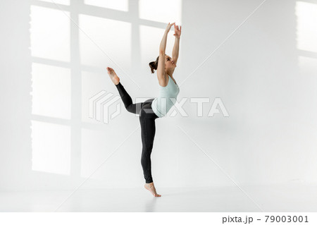 Woman practising rhythmic gymnastics alone Woman practising rhythmic gymnastics alone 79003001