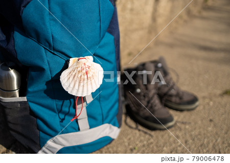Close up of a seashell symbol of Camino de Santiago on backpack and trekking boots. Pilgrimage to Santiago de Compostela. Copy space 79006478