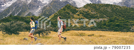 Hikers hiking on trail in mountain landscape background. Couple healthy people living an active lifestyle on Hooker Valley Track, New Zealand. Famous attraction for summer travel, banner crop Hikers hiking on trail in mountain landscape background. Couple healthy people living an active lifestyle on Hooker Valley Track, New Zealand. Famous attraction for summer travel, banner crop 79007235