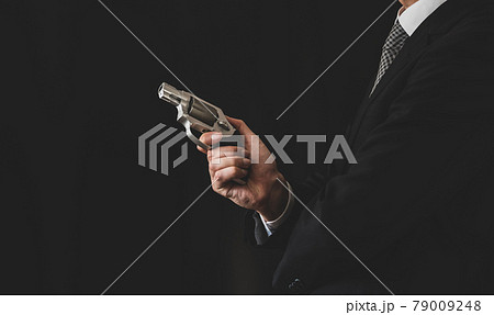 拳銃を構えるスーツの人物 79009248