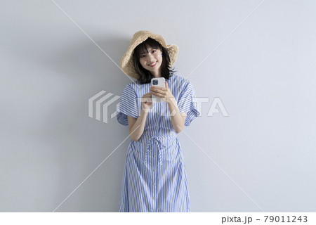 スマートフォンを使う麦わら帽子を被った女性 スマートフォンを使う麦わら帽子を被った女性 79011243