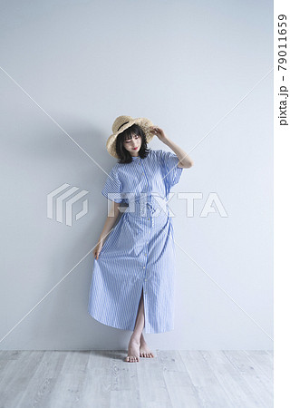 麦わら帽子を持った夏ファッションの女性の写真素材 [79011659] - PIXTA