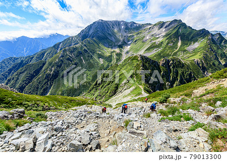 立山の広大な山脈と前剱の険しい岩場を登る登山者たち 79013300