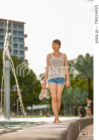 ケアンズのラグーンプールサイドを歩くハーフの美女の写真素材