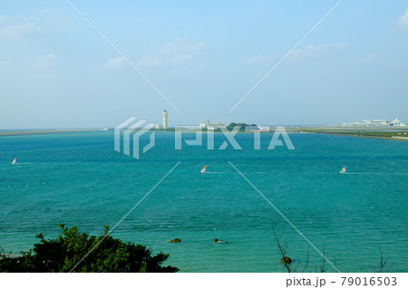 沖縄那覇空港をバックに風に乗り進むウィンドサーフィン 79016503