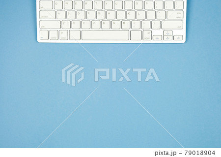 Compact white wireless keyboard on a blue background. Copy space. 79018904
