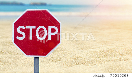 Lockdown concept. Stop sign on the beach by the sea. Ban on the sea, beaches, recreation and vacations. Coronavirus restrictions and bans 79019263